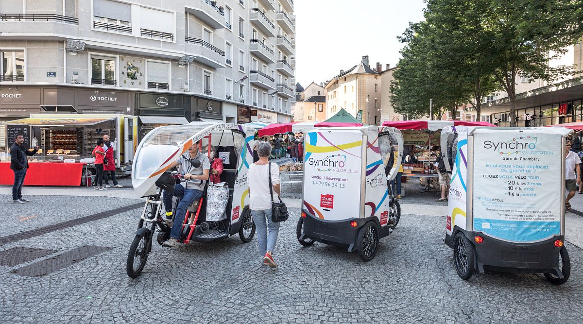 Des vélos triporteurs attendent de clients en centre-ville de Chambéry