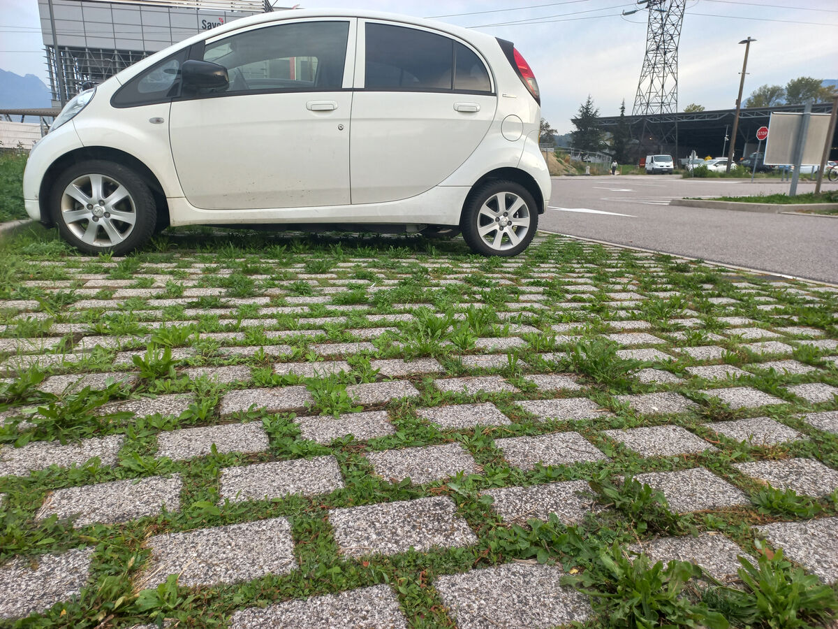 Un parking avec des dalles et de l'herbe