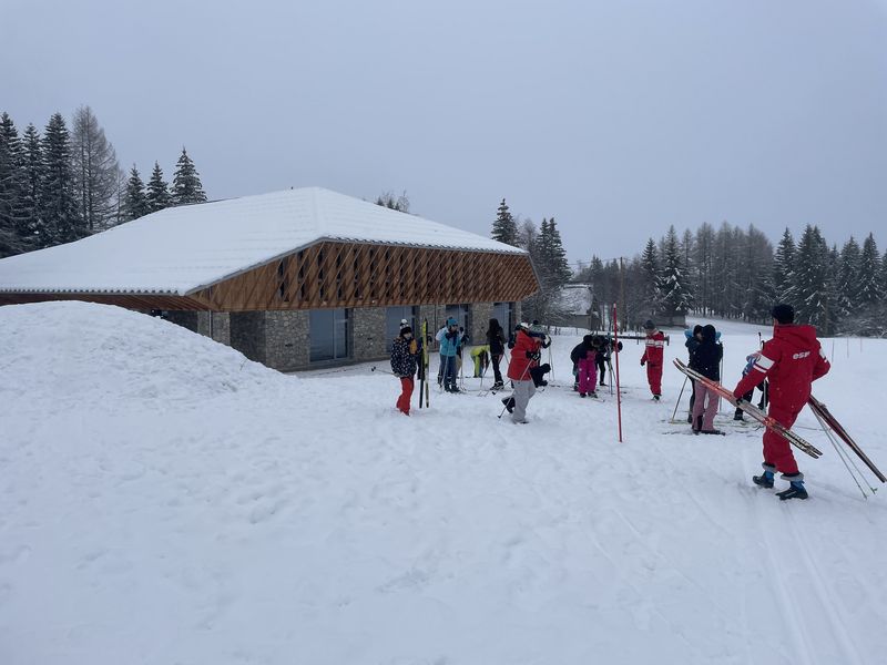 Centre nordique éducatif sportif avec des élèves chaussés en ski sur les pistes. 