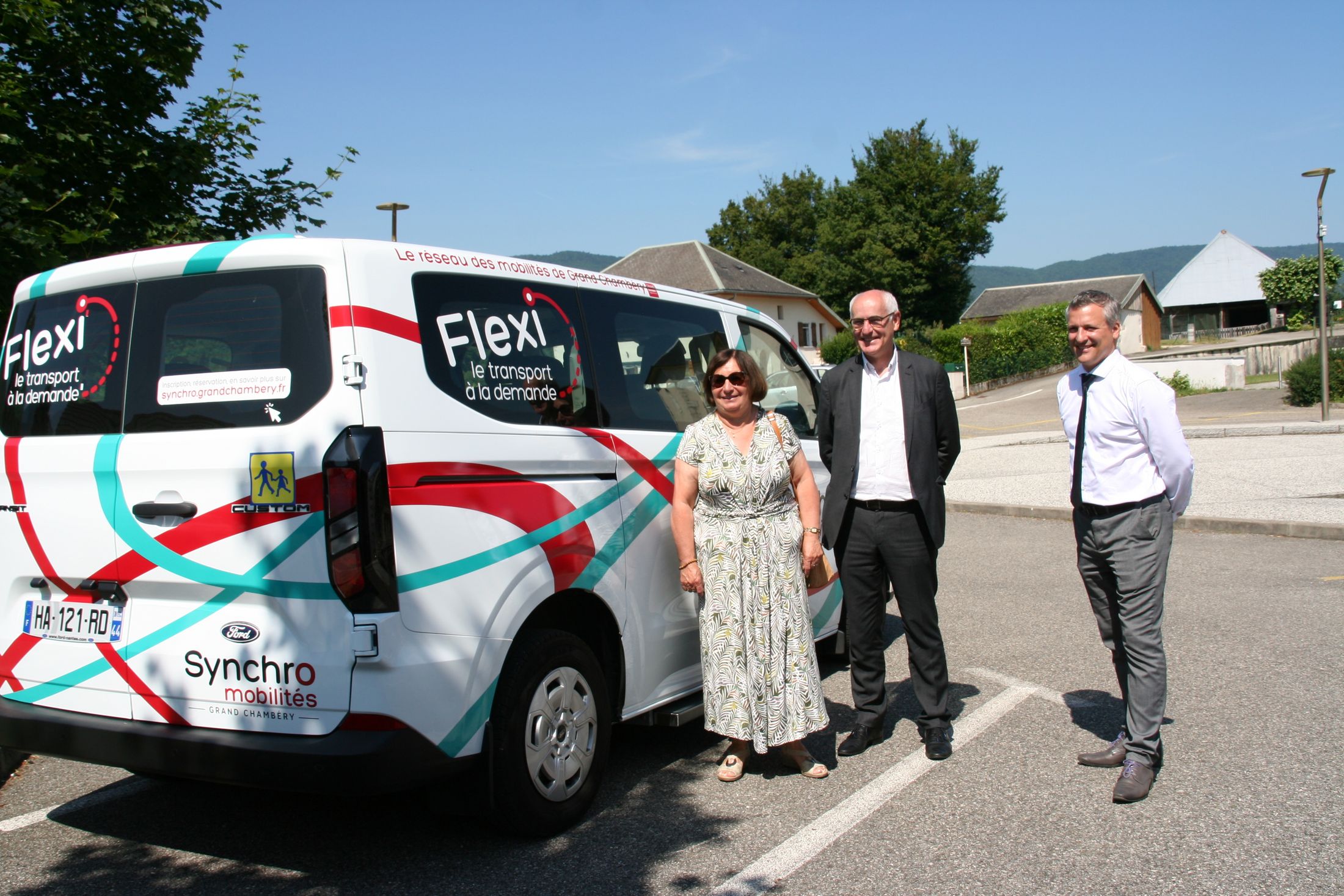 Trois élus posent devant un minibus permettant le service de transport à la demande.