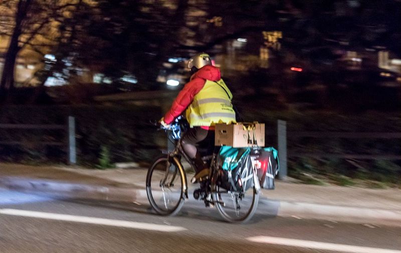 Un vélociste roulant de nuit sur une piste cyclable