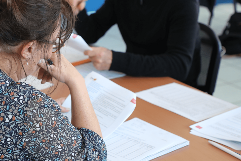 des personnes assisent autour d'une table travaillent