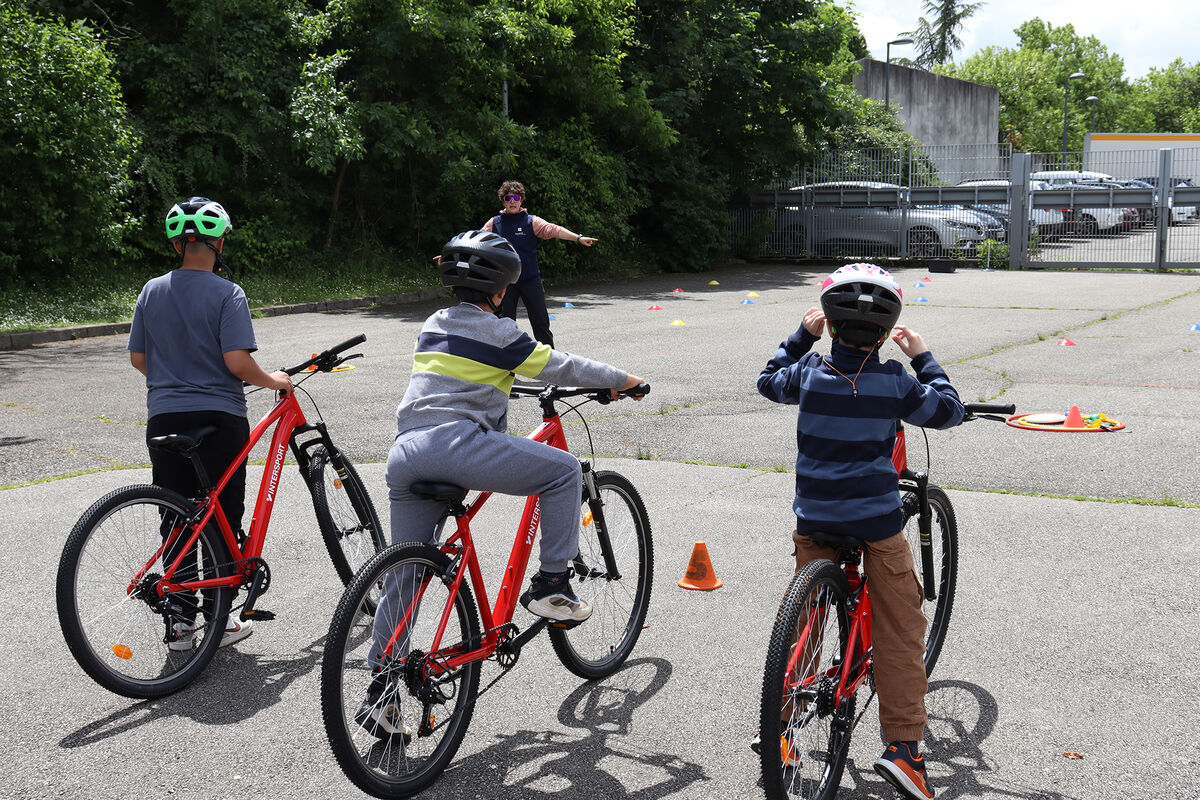 Des enfants apprenant le vélo avec un animateur de la Vélostation