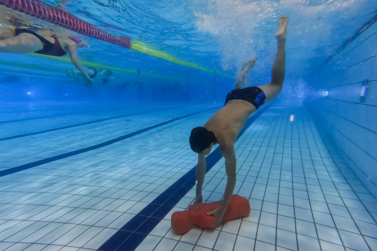 Adolescent qui récupère au fond de l'eau un mannequin lors du cours Adoswim