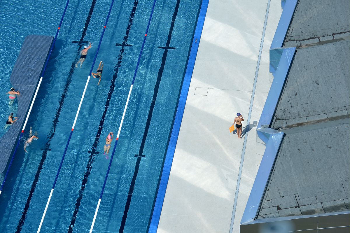 Des nageurs font des longueurs dans le bassin extérieur de la piscine