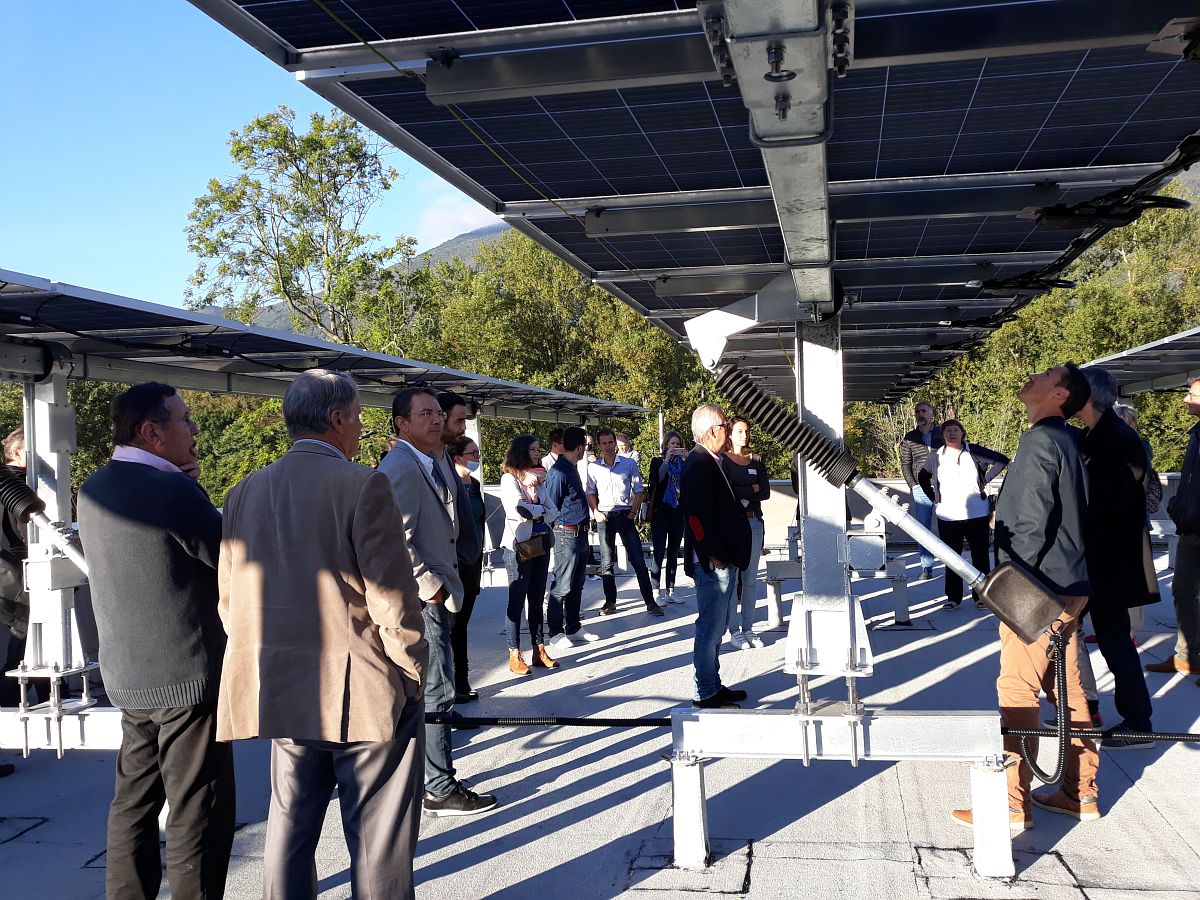 Des personnes sous des panneaux solaires.