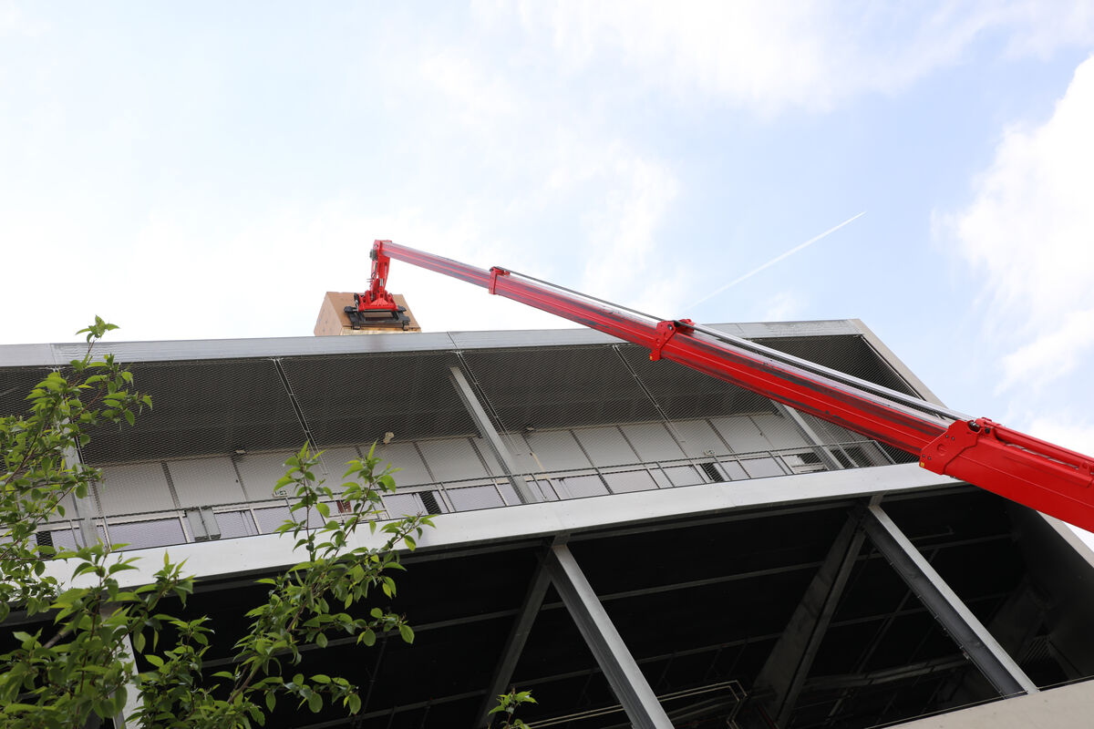 Une grue monte des panneaux photovoltaïques sur le toit du Chambéry Savoie Stadium