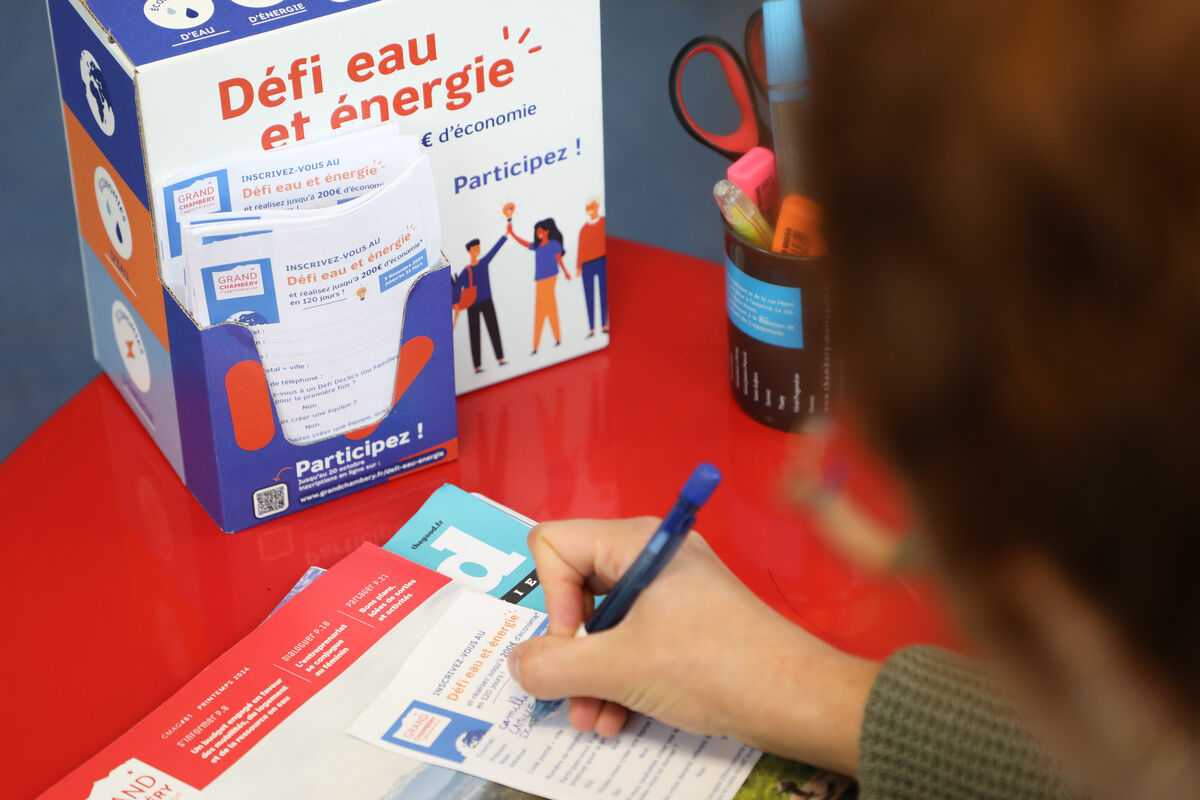 une femme remplit un bulletin d'inscription pour le défi eau et énergie 