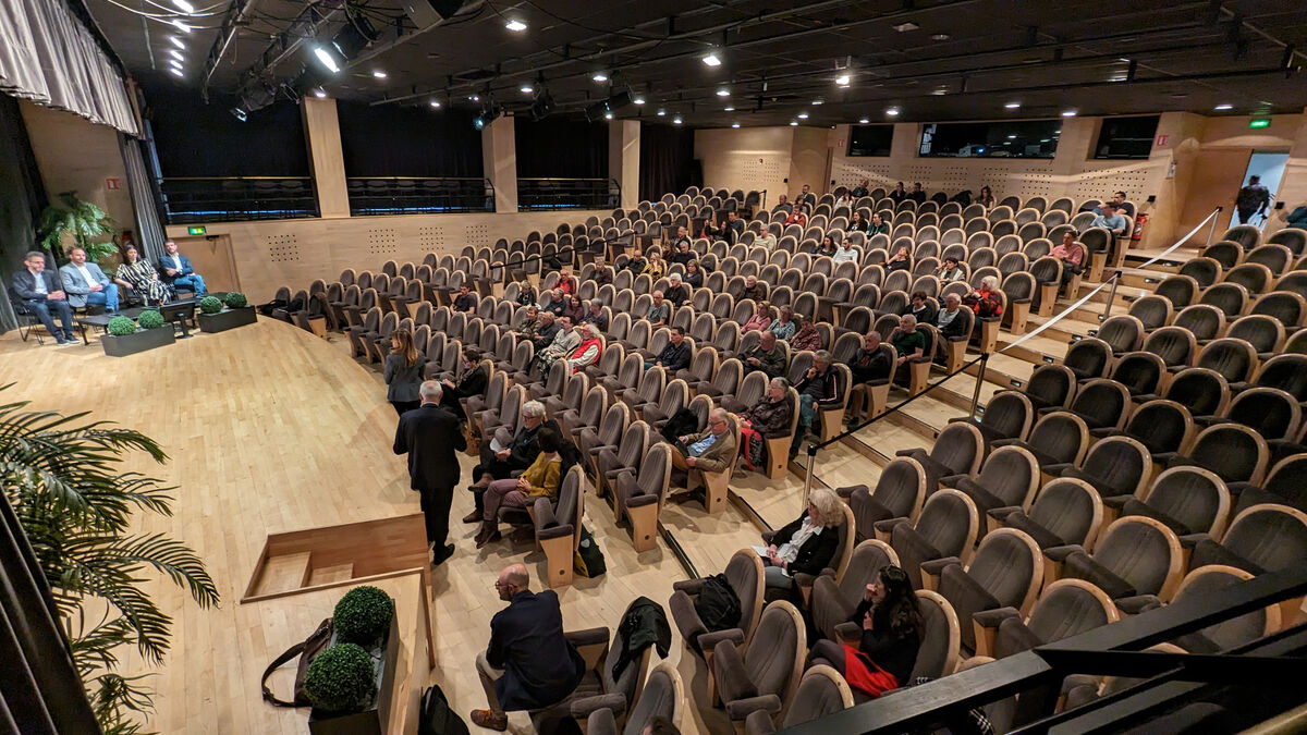 des personnes assisent dans une salle de conférence