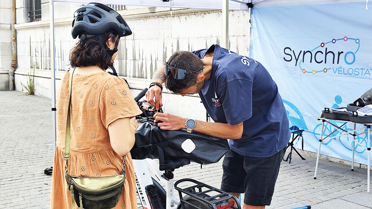 L'animateur de la Vélostation de Synchro mobilités qui réalise un contrôle technique d'un vélo une passante au Palais de Justice.
