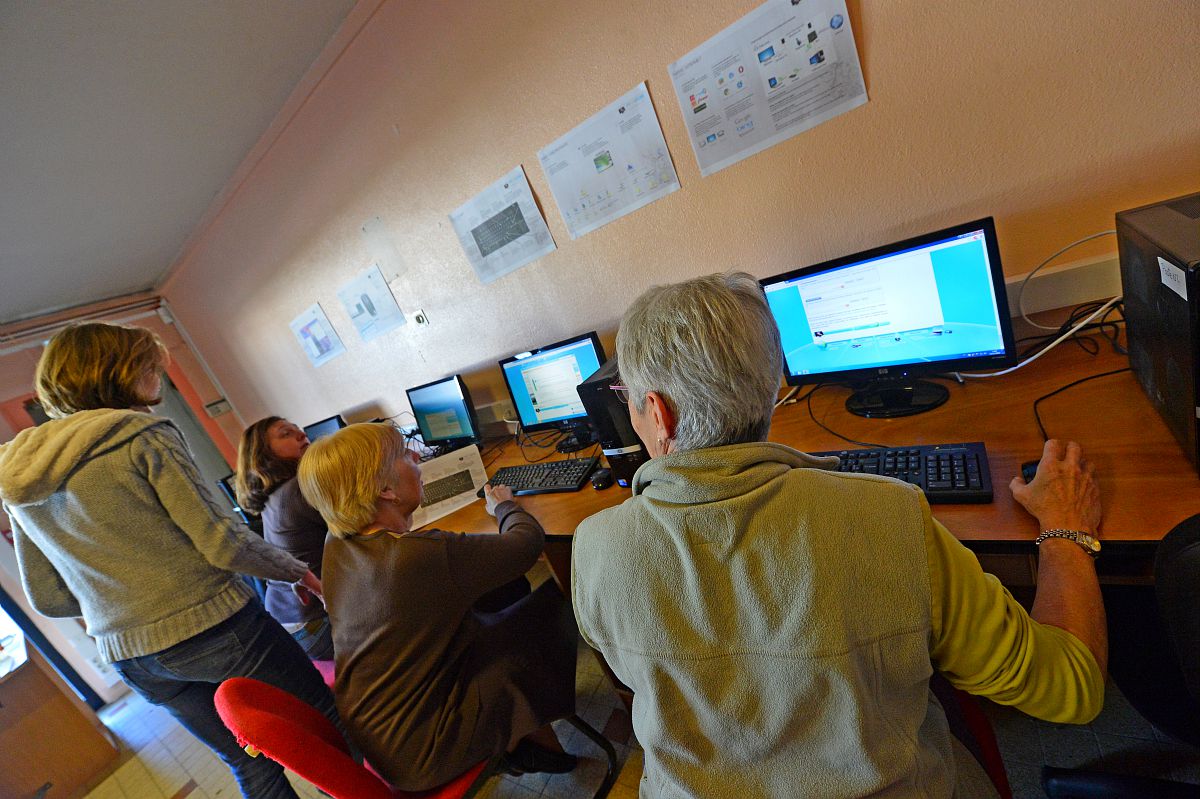 Des personnes âgées s'initient à internet dans une médiathèque