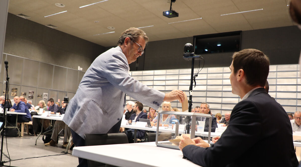 Une personne dépose son bulletin de vote dans l'urne.
