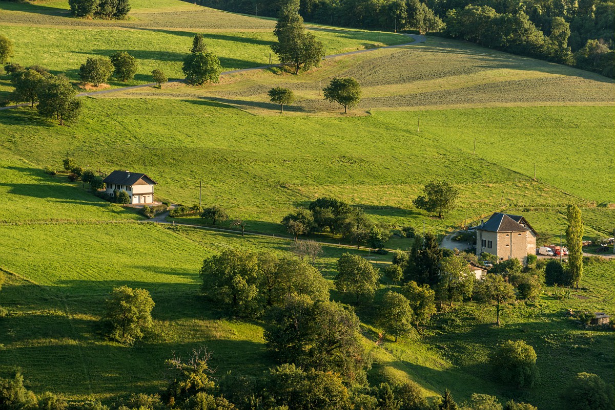 Un paysage de montagne avec quelques maisons dispersées