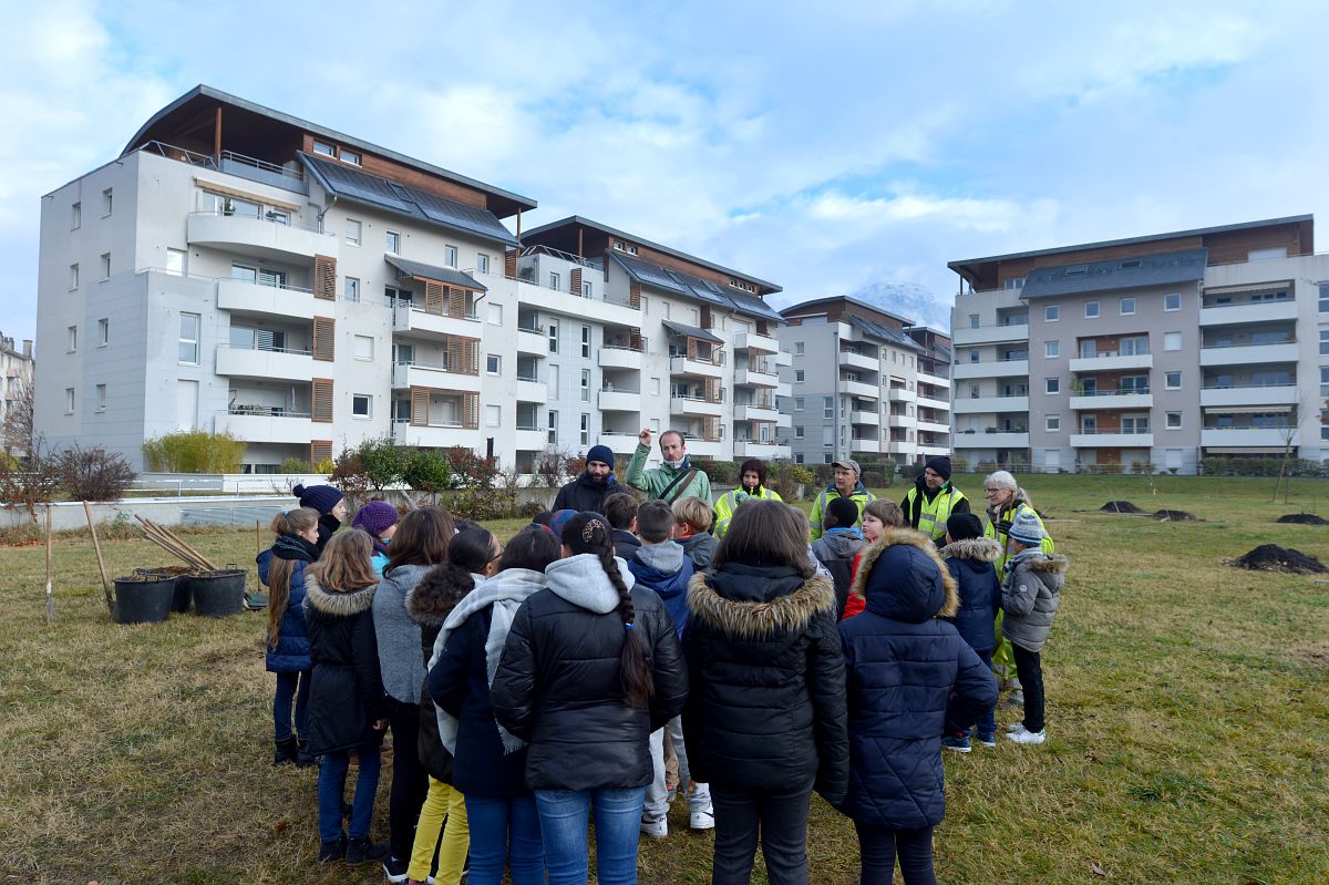 Des personnes dans un jardin devant un immeuble.