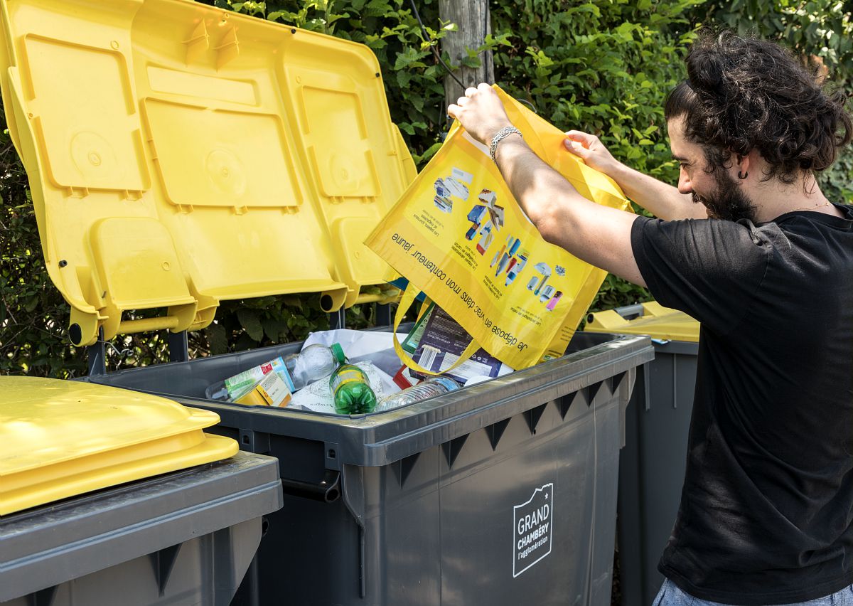 Dépôt des déchets en vrac dans le bac jaune à l'aide d'un cabas de pré-collecte.