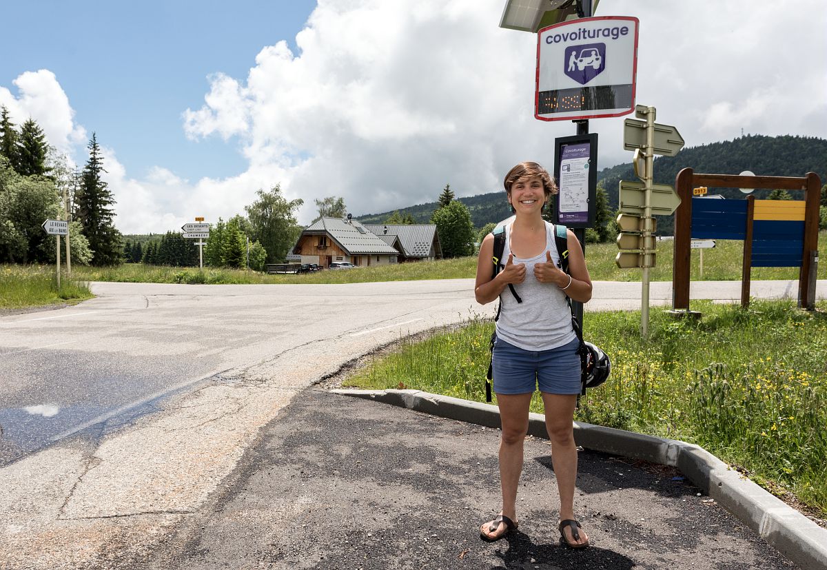 Une usagère qui attend à un arrêt de covoiturage.