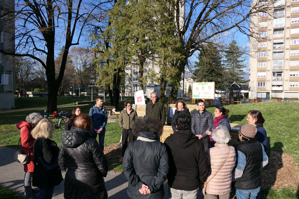 Des personnes sont autour d'un site de compostage collectif lors d'une inauguration
