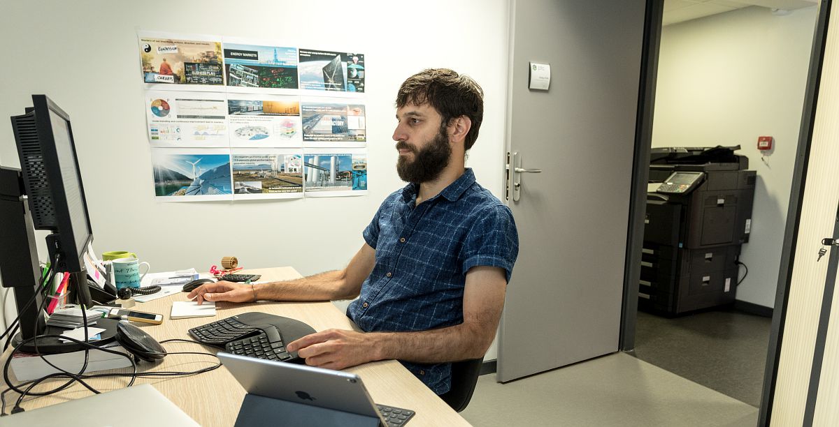 Une personne dans un bureau travaille sur son ordinateur.