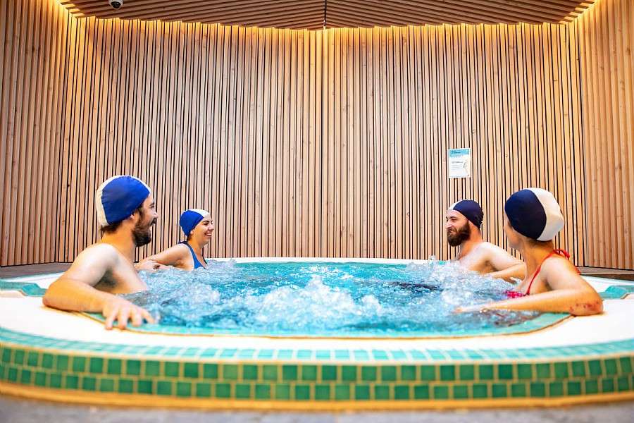 Quarte personnes se baignant dans le spa de la piscine aqualudique du Stade.