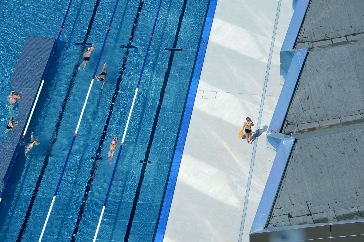 Des nageurs font des longueurs dans le bassin extérieur de la piscine